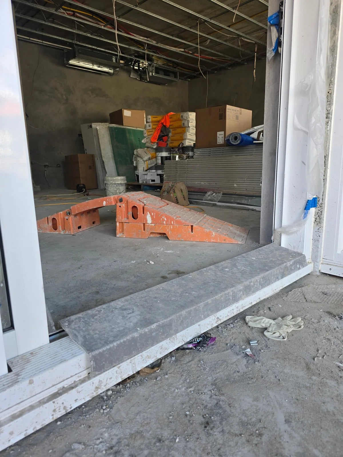 Hard Shell Threshold Covers installed along a construction site sliding door track